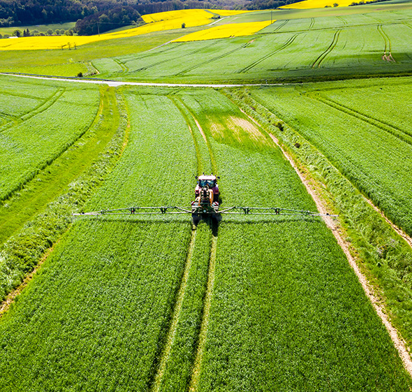 tractor spreading fertilizer in big field